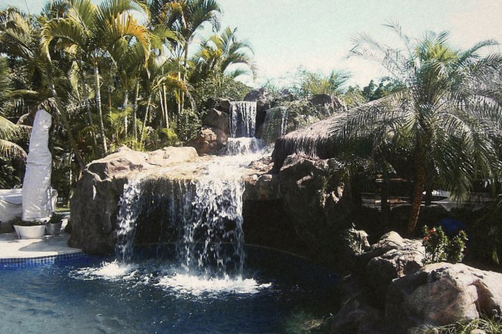 Piscina com cascata de pedra entre palmeiras, em 2005