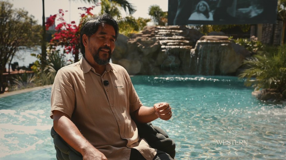 Ricardo Botelho à beira de uma piscina natural com cascata de pedra